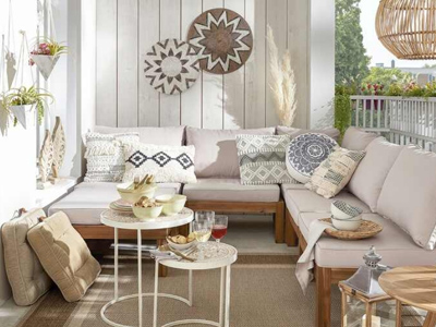 Terrasse mit Ecksofa, Kissen, Tischen, Wandkunst und Pflanzen